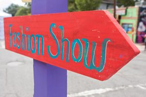Handmade sign points festival patrons in right direction for fashion show.